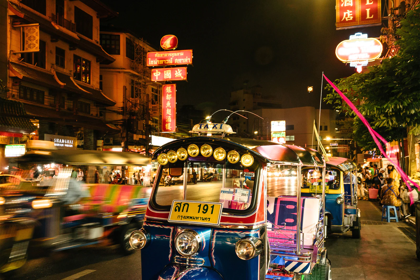 Tuk Tuk driving by busy street in Bangkok