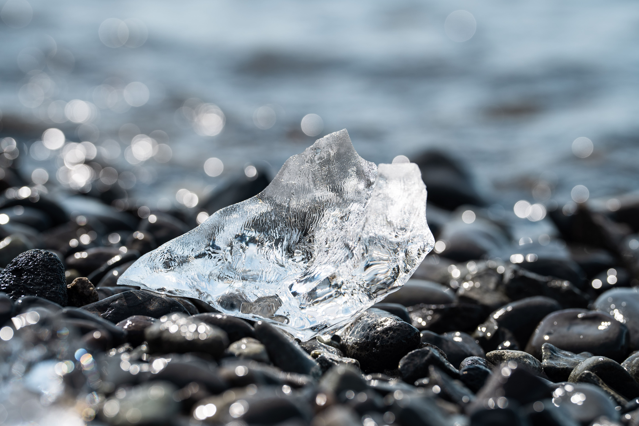 Close-up of a piece of glacial ice on the basalt rock along the sea