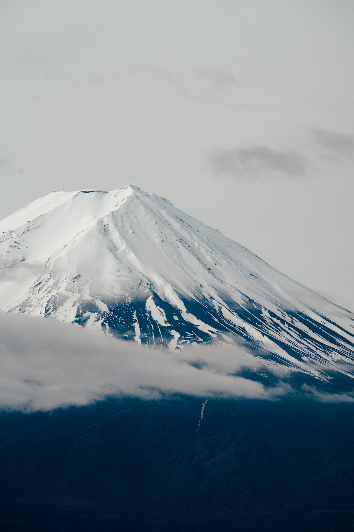 Close-up of the top of Mt Fuji with some clouds in front of it